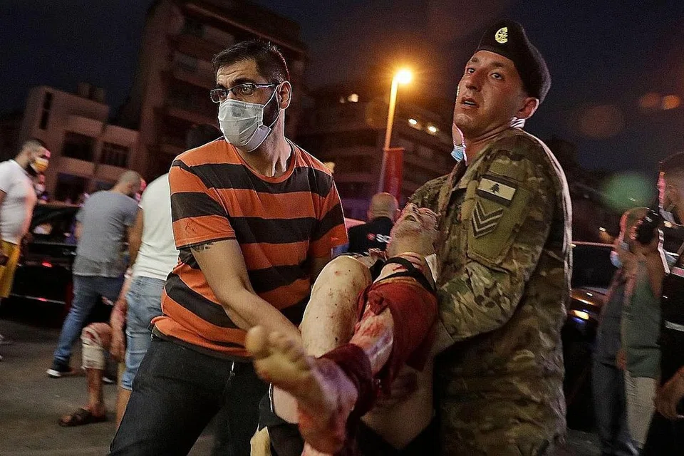 SELAMATKAN MANGSA: Mangsa letupan dibawa anggota tentera Lebanon dan penduduk awam untuk mendapatkan rawatan di hospital di Beirut. - Foto-foto AFP