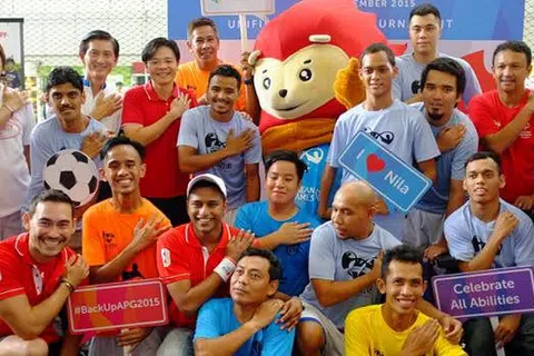 SEMARAKKAN SEMANGAT KESUKANAN: Encik Lawrence Wong (berdiri, empat dari kiri) bergambar kenangan bersama pemain bola sepak pasukan Cerebral Palsy Singapura dan bekas pemain Singapura termasuk Fandi Ahmad (berdiri di kanan). - foto HAKIM YUSOF
