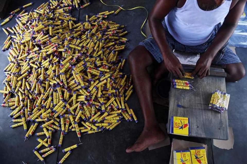 Gambar yang diambil pada 14 Oktober menunjukkan seorang pekerja membungkus mercun di Sivakasi. - Foto AFP