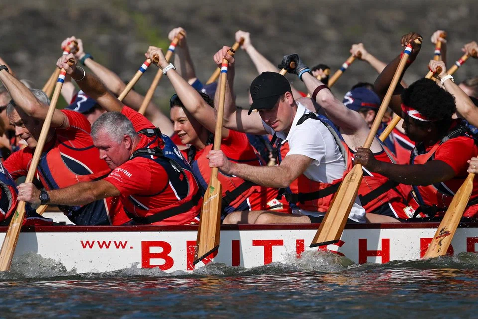 GIGIH KAYUH: Putera William (berbaju putih) mengambil bahagian dalam satu sesi latihan Pasukan Lumba Bot Naga Britain di Marina Reservoir pada pagi Isnin.
