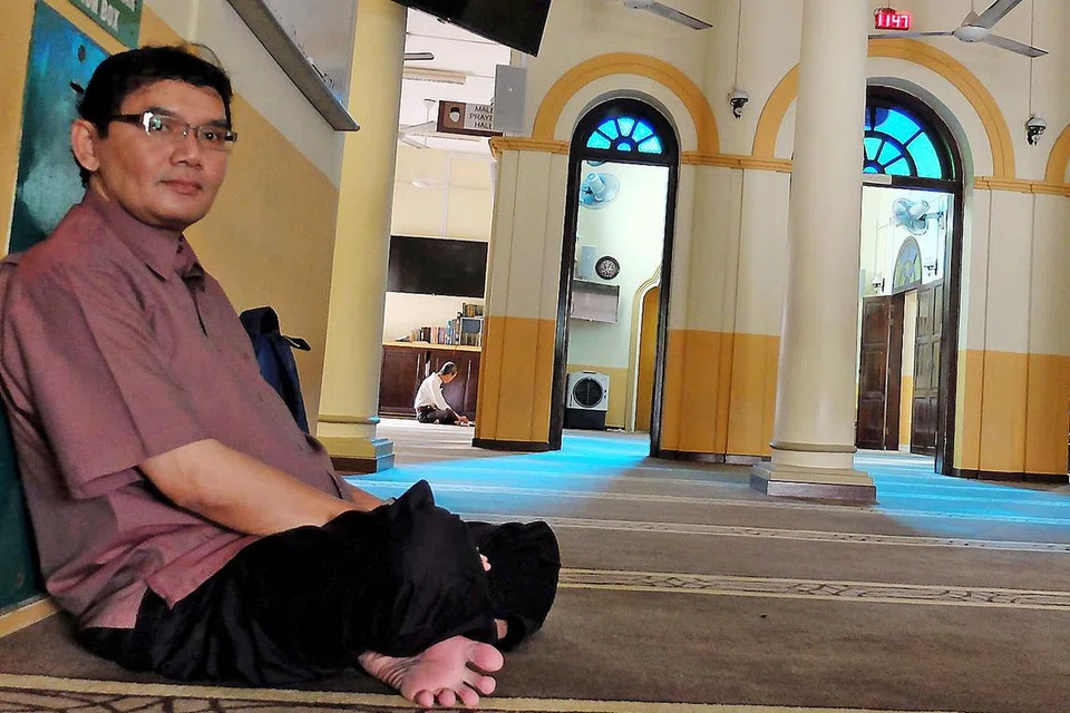 MASJID DEKAT MRT: Seorang anggota jemaah, Encik Mohd Fadzil Ahmad, berehat sementara menunggu waktu solat di Masjid Al-Abrar yang terletak dekat stesen Telok Ayer. - Foto KHALID BABA 