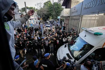 DIKERUMUNI: Wartawan dan jurukamera mengelilingi ambulans yang memindahkan Maradona setelah beliau keluar dari Klinik Olivos di Buenos Aires, Argentina. - Foto EPA-EFE