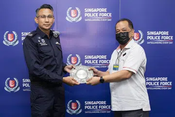 ANUGERAH: Encik Mohamed Tahar Manaf (kanan) menerima Anugerah Kerjasama Masyarakat daripada Timbalan Penolong Pesuruhjaya (DAC) Masagoes Idris Hussain. - Foto SPF