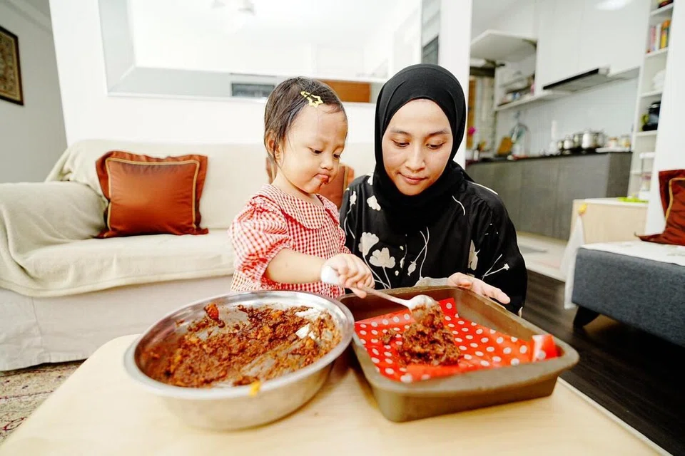  Cik Khadijah Abdul Majid, melihat anaknya, Sarah Muhammad Zaini, menyenduk adunan ‘brownies’ keledek ke dalam loyang. 