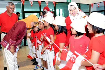 Sambut Hari Kebangsaan bersama penduduk di Pasir Ris : Cik Halimah Yacob, yang diiringi Pengarah Eksekutif Angkatan Karyawan Islam (AMP), Encik Mohd Anuar Yusop, menghadiri sambutan Hari Kebangsaan di Kelab Masyarakat Pasir Ris East semalam. Cik Halimah antara lain bertemu dengan kanak-kanak daripada Tadika Kidz Meadow MERCU Learning Point di majlis itu yang dimeriahkan lagi dengan karnival permainan, kegiatan dan makanan. - Foto KHALID BABA