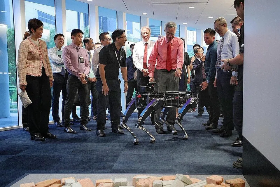 ANJING ROBOT: Perdana Menteri, Encik Lee Hsien Loong, memberikan reaksi semasa menyaksikan pergerakan Rover-X iaitu sejenis anjing robot di pelancaran Agensi Sains dan Teknologi Home Team atau dikenali sebagai HTX semalam. - Foto BH oleh JASON QUAH