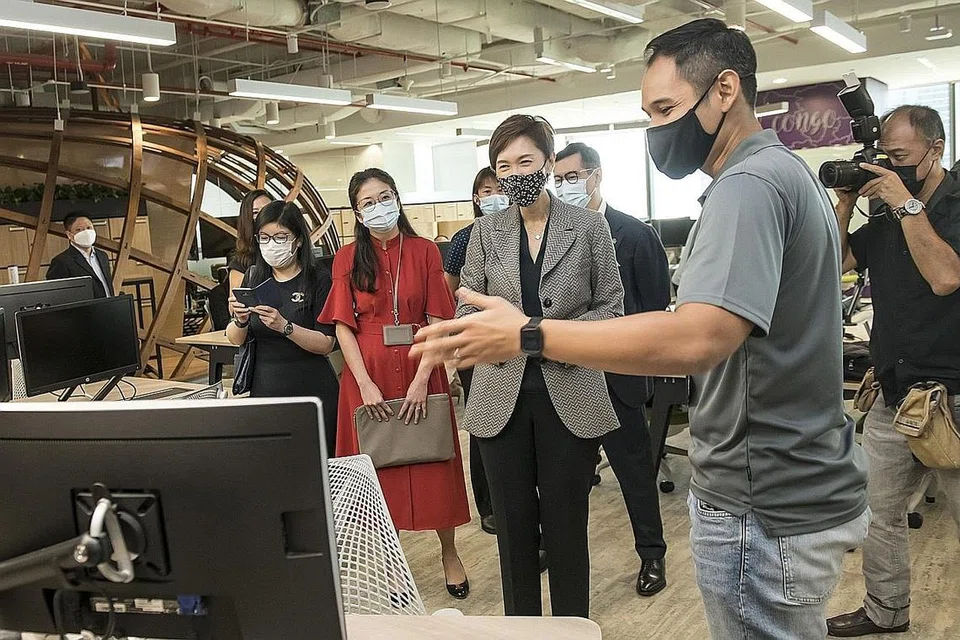 TUKAR KERJAYA: Encik Muhammad Shirazee Ahmad (dua dari kanan) melepaskan pekerjaan sebagai jurutera rangkaian dan kemudian menyertai Program Rendaman (Immersion) Teknologi dalam Kewangan dan kini merupakan seorang pelatih keselamatan siber dalam pengurusan risiko teknologi di Prudential Singapore. Gambar ini diambil baru-baru ini semasa lawatan Cik Josephine Teo (tengah), yang ketika itu Menteri Tenaga Manusia, ke pejabat Prudential. - Foto PRUDENTIAL SINGAPORE