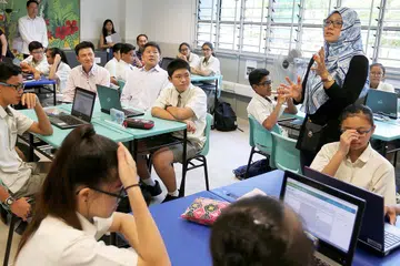 ALAMI SUASANA PEMBELAJARAN DALAM KELAS: Menteri Pendidikan (Sekolah), Encik Ng Chee Meng (berkemeja lengan panjang putih di tengah kelas), menyertai kelas Matematik yang dikendalikan Cikgu Khairyn Adriana di Sekolah Menengah Admiralty semalam. - Foto THE STRAITS TIMES