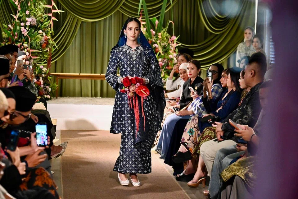 The Wedding Brocade menampilkan busana songket dengan sentuhan moden menerusi potongan berstruktur, gaya berlapis dan perincian penuh yang tetap mengekalkan seri tradisional pengantin Melayu.