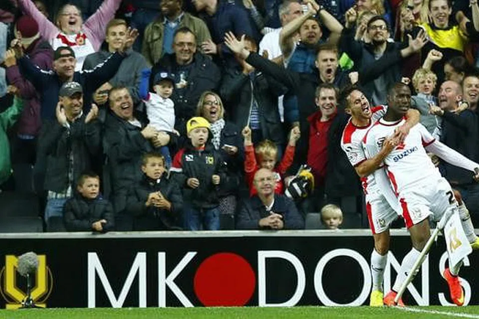 MACAM SUDAH MENANG PIALA: Pemain MK Dons, Benik Afobe (kanan), meraikan golnya dengan rakan sepasukan, George Baldock, di hadapan para penyokong semasa kemenangan hebat 4-0 ke atas Manchester United dinihari semalam. - Foto-foto REUTERS