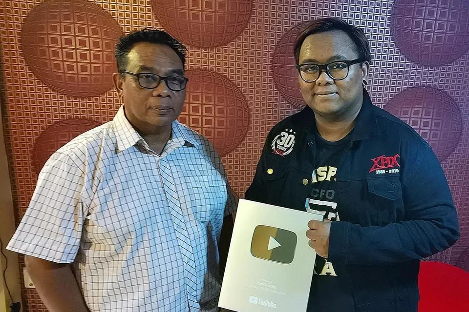 ALIH ARAH: Ketua Pegawai Eksekutif Life Records International, Osman Arrifin (kiri) bersama Muhammad Ikhmal Osman dari Life Records menerima plak dari YouTube apabila saluran 'Jom Karaoke' mendapat 100,000 langganan. Gambar diambil sebelum pemutus rangkaian jangkitan.