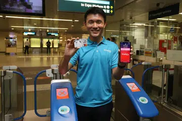PAPAR KEMUDAHAN: Encik Baey Yam Keng, telah melawat satu pameran SimplyGo yang diadakan di stesen MRT Downtown dan menunjukkan kemudahan yang boleh dimanfaatkan pengguna. - Foto LIANHE ZAOBAO