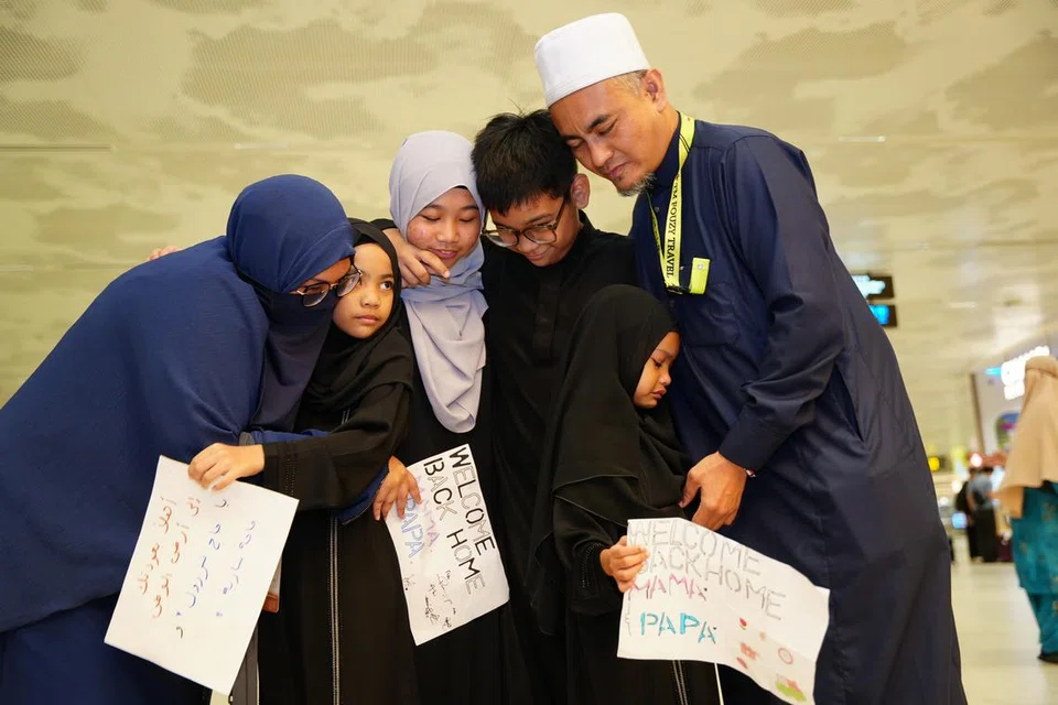 Encik Mohamad Nazrul Ahmad (kanan) bersama isterinya, Cik Sariah Rosly (kiri), memeluk  keempat-empat anak mereka di Lapangan Terbang Changi pada 5 Julai setelah berpisah selama 29 hari bagi menunaikan ibadah haji di Arab Saudi.