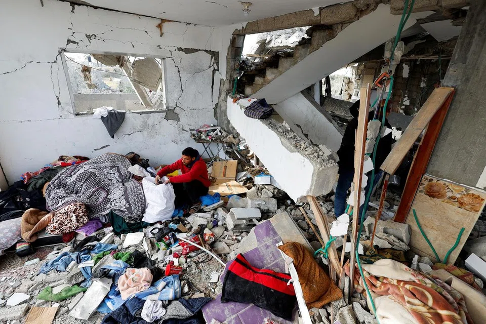 Seorang penduduk mencari barangan yang boleh diselamatkan selepas pengeboman Israel ke atas sebuah rumah di Rafah, selatan Gaza pada 26 Mac.