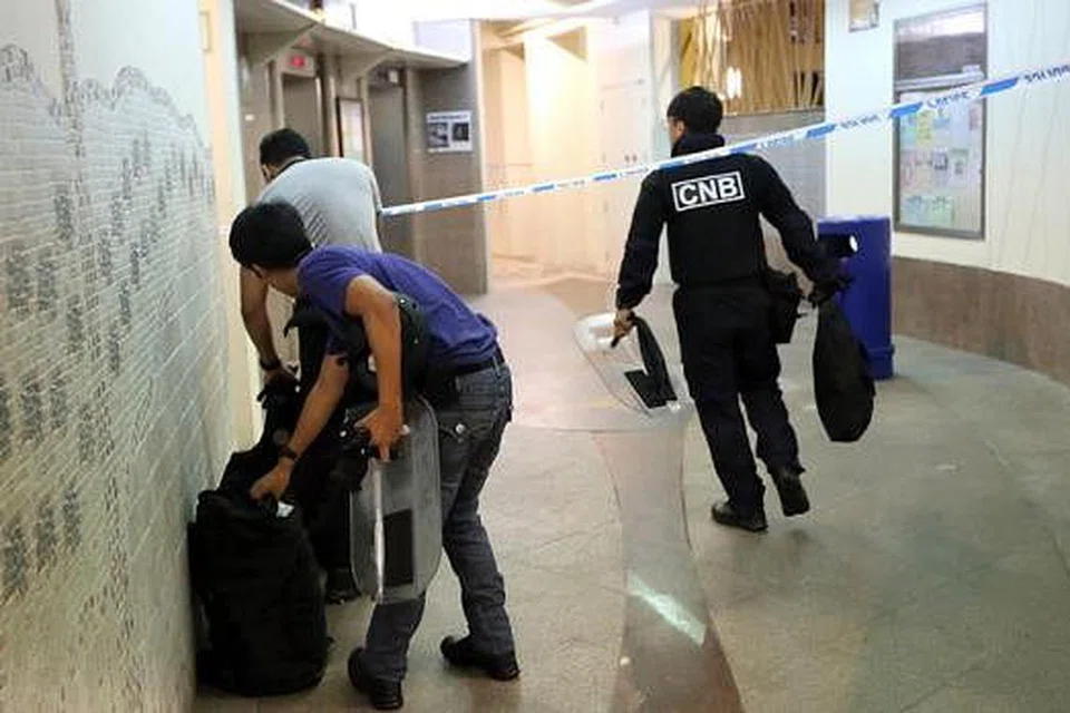 OPERASI ANTIDADAH: Para pegawai CNB bersiap sedia melancarkan operasi mencegah penyalahgunaan dadah di sebuah kejiranan di Woodlands. - Foto TNP 