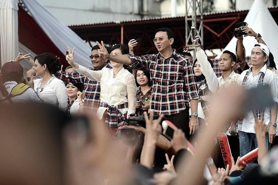 ALU-ALUKAN SOKONGAN: Ahok (empat dari kanan) menunjukkan tanda 'keamanan' ke arah para penyokongnya pada rapat pilihan raya gabenor terakhirnya kelmarin. - Foto AFP.