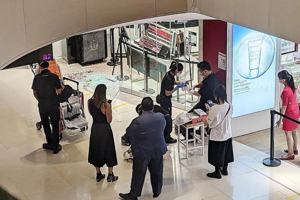 KEJADIAN TIDAK DIDUGA: Pegawai SCDF merawat seorang kakitangan kedai jenama Bobbi Brown setelah sebuah pintu panel kaca pecah, menyebabkan beliau mengalami luka di lengannya. - Foto BH oleh CHARMAINE NG
