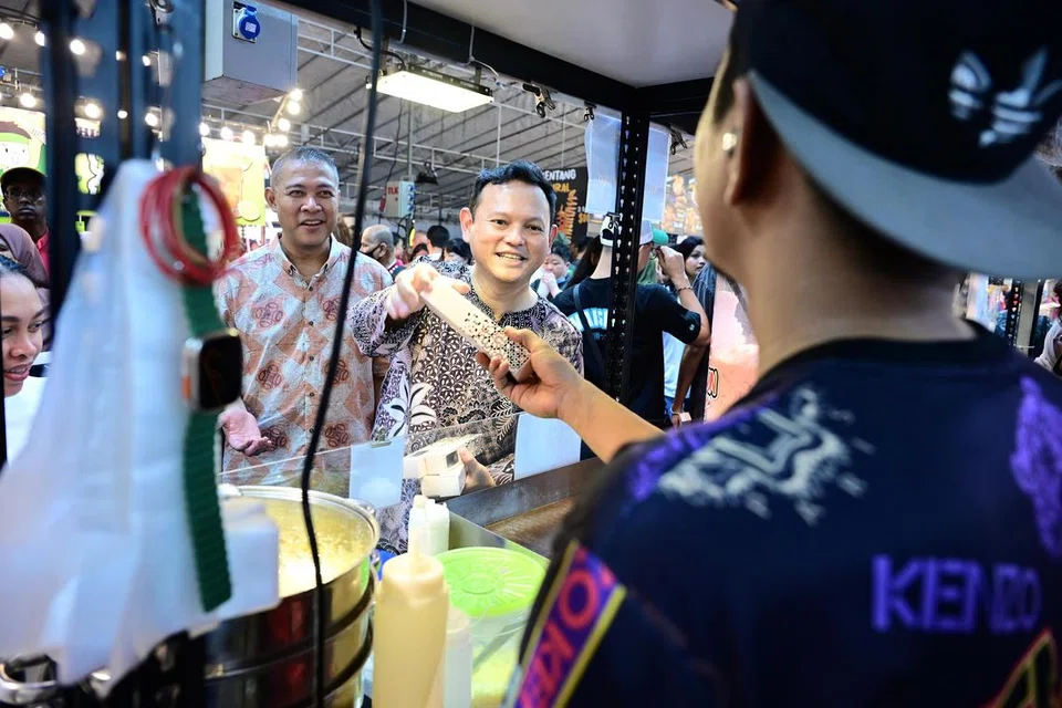 Menteri Negara Kanan (Pertahanan merangkap Tenaga Manusia), Encik Zaqy Mohamad (tengah), mengunjungi gerai-gerai yang sudah dibuka di BazaRia Marsiling yang terletak bersebelahan stesen MRT Woodlands pada 10 Mac.