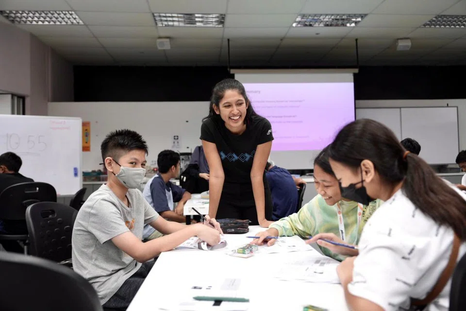 BIMBING PELAJAR: Fasilitator di Pusat Sains Singapura membimbing para pelajar menengah rendah dalam aktiviti dan eksperimen yang menarik semasa Kem Cip Micron pada Isnin. 
