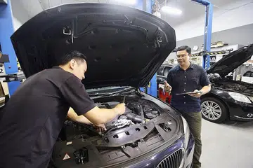 KHIDMAT BAIKI KERETA: Pemilik Juzz Performance, Encik Khairil Anwar Rasno (kanan) bersama seorang mekaniknya. - Foto BH oleh IQBAL FAIZAL
