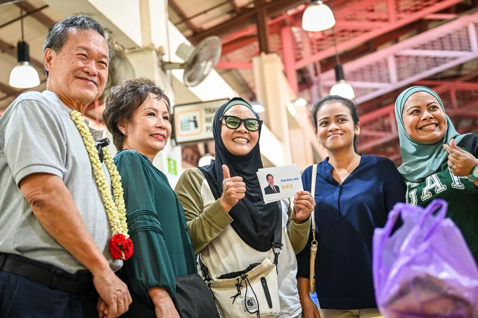TEMU RAMAH: Calon Presiden Encik Tan Kin Lian (paling kiri), dan isterinya Cik Tay Siew Hong (dua dari kiri) kelihatan bergambar dengan pelanggan di Pasar Geylang Serai.