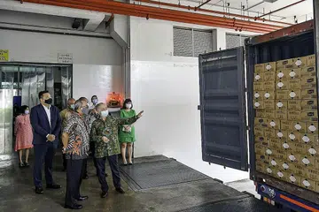 TINJAU SUMBANGAN: (Depan dari kiri) Duta Besar Indonesia ke Singapura Suryo Pratomo mendengar taklimat dari wakil Borden Eagle Group Encik Edy HT mengenai kiriman sanitiser tangan untuk membantu pemerintah Indonesia mengatasi wabak Covid-19. - Foto BORDEN EAGLE GROUP