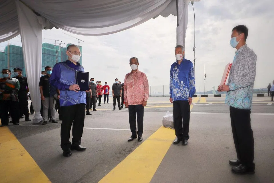 RASMI KINI: (Dari kiri) Menteri Pengangkutan Malaysia, Datuk Seri Wee Ka Siong; Perdana Menteri Tan Sri Muhyiddin Yassin; Perdana Menteri Lee Hsien Loong, dan Menteri Pengangkutan Ong Ye Kung bertemu di garisan sempadan antarabangsa di Koswe bagi merasmikan penyambungan projek RTS Link. - Foto BH oleh GAVIN FOO