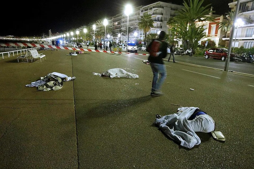 RAMAI TERKORBAN: Mayat mangsa yang ditutup kelihatan bergelimpangan di jalan raya selepas seorang penyerang yang memandu sebuah trak merempuh ke arah orang ramai yang sedang menyaksikan pertunjukan bunga api sempena Hari Bastille di bandar French Riviera. - Foto REUTERS