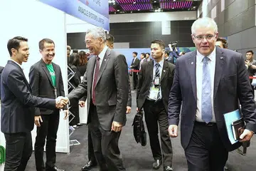 LAWAT PAMERAN: Perdana Menteri Lee Hsien Loong (sedang berjabat tangan) bersama Perdana Menteri Australia, Encik Scott John Morrison (kanan), melawat pameran yang antara lain mempamerkan usaha Negara Bijak Singapura dan rancangan rakan luar Asean dan sektor swasta untuk memperkukuh kerjasama bandar bijak bersama Asean, di Sidang Puncak Asean, semalam. - Foto KEMENTERIAN PENERANGAN DAN PERHUBUNGAN