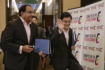 BENTANG STRATEGI: Encik S Iswaran (kiri) dan Encik Heng Swee Keat (kanan) tiba bagi sidang media laporan Jawatankuasa Ekonomi Masa Hadapan semalam. - Foto THE STRAITS TIMES