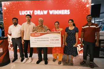 Pengurus Mustafa Jewellery, Encik Mohamed Ghouse (tiga dari kiri), menyerahkan cek kepada lima pemenang cabutan bertuah pada September 2024. Setiap pemenang menerima $6,600.