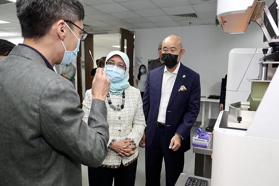 BANTUAN HEBAT: Presiden Cik Halimah Yacob mengunjungi syarikat Structo Jumaat lalu dan menyaksikan bagaimana teknologinya dijalankan. Beliau memuji Structo kerana "bantuan hebat" yang dihulurkan syarikat itu semasa kekurangan kit ujian swab Covid-19. - Foto LIANHE ZAOBAO