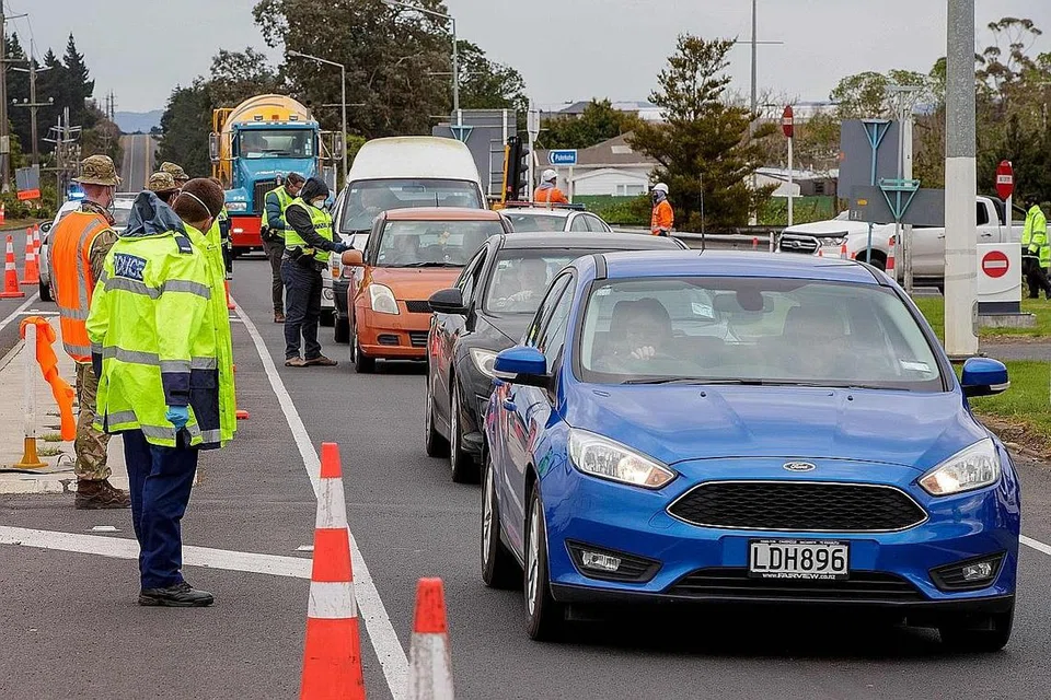 LAKUKAN PEMERIKSAAN: Anggota polis dan tentera sedang memeriksa kenderaan yang mahu keluar dari Auckland yang kini di bawah perintah sekatan pergerakan yang ketat. - Foto AFP