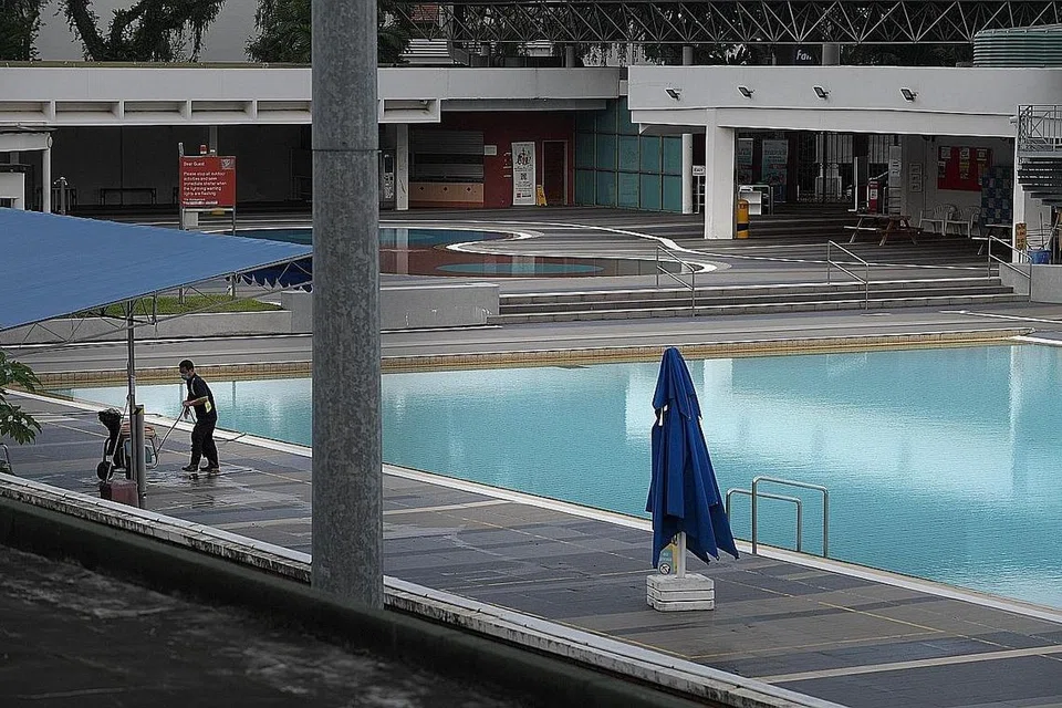 BIAR BERSIH DAN SELAMAT: Seorang pekerja melakukan kerja pembersihan di Kompleks Renang Toa Payoh, yang kosong Ahad lalu tetapi bakal menyambut orang ramai mulai esok. - Foto BH oleh ALPHONSUS CHERN 