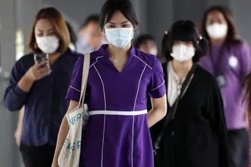 Orang ramai memakai pelitup muka semasa di kawasan awam di Bangkok, Thailand, pada 20 Mei 2025. Thailand telah melaporkan lonjakan besar dalam kes Covid-19 selepas jumlah jangkitan meningkat kepada 33,030 dalam tempoh 11-17 Mei, termasuk sekurang-kurangnya 6,000 kes di Bangkok dengan dua kematian, menurut Jabatan Kawalan Penyakit. 