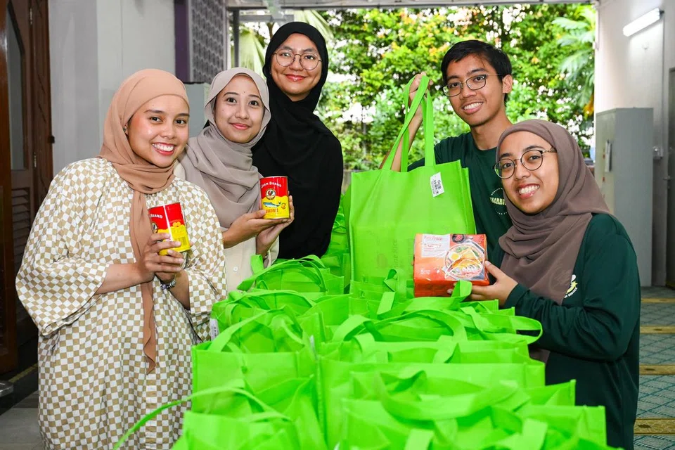 Mahasiswa NUS - (dari kanan) Cik Aisyah Nurul Izza, Encik Ahmad Ihsan Aziz, Cik Rukhsana Bi D/O Abdul Wahid, Cik Siti Zhuraifah Kamaruddin dan Cik Nabila Zolkifli - singsing lengan untuk usaha SalamSG Gives yang diadakan di daerah barat pada 22 Februari.