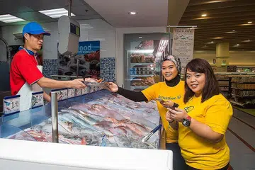 PEKERJAAN SHOPPER BEE: Tugas pasangan adik-beradik Cik Shahidah Abdul Shukor (kanan) dan Cik Nur Haffidah ialah memilih bahan masakan segar serta keperluan dapur dan rumah buat pelanggan penyedia khidmat barang runcit Honest Bee. - Foto LEA ZALEHA