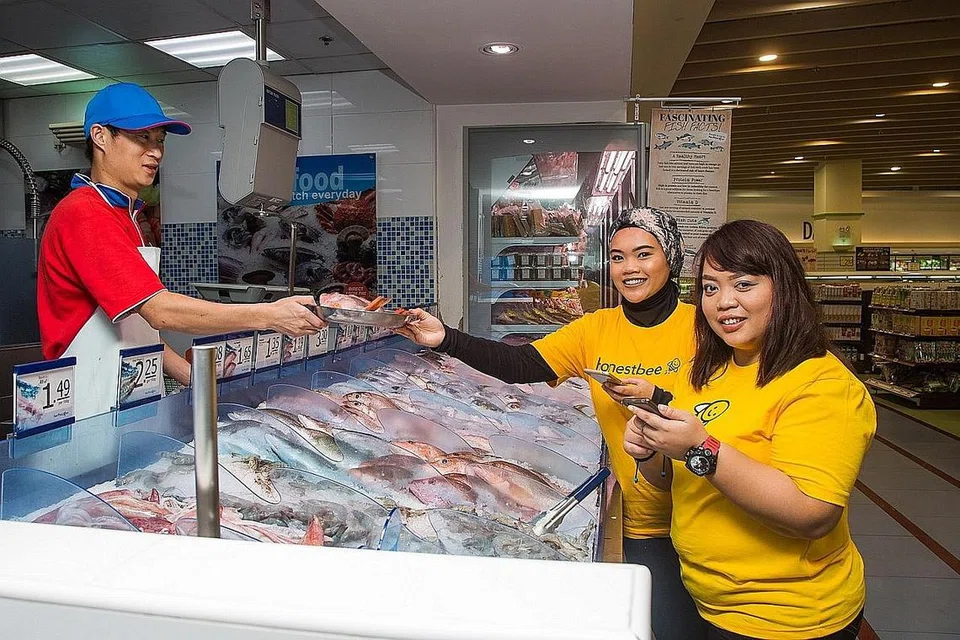 PEKERJAAN SHOPPER BEE: Tugas pasangan adik-beradik Cik Shahidah Abdul Shukor (kanan) dan Cik Nur Haffidah ialah memilih bahan masakan segar serta keperluan dapur dan rumah buat pelanggan penyedia khidmat barang runcit Honest Bee. - Foto LEA ZALEHA
