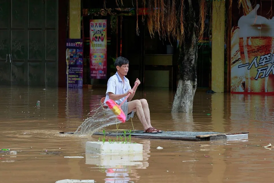 TIADA ROTAN AKAR PUN BERGUNA: Seorang penduduk menggunakan bahan terpakai sebagai sampan untuk mereda banjir di Liuzhou, wilayah Guangxi. - Foto AFP 