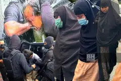 Antara ahli keluarga suspek serangan Balai Polis Ulu Tiram, Johor, dikawal ketat anggota polis ketika dibawa ke Mahkamah Johor Bahru, Johor, untuk pendakwaan kes pada 19 Jun. 