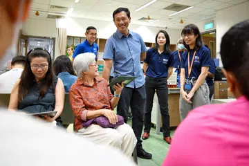 Menteri Kesihatan, Encik Ong Ye Kung (tiga dari kanan), melihat bagaimana peserta disaring semasa sambutan ulang tahun ke-20 kohort Kajian Kesihatan Penduduk Singapura yang diadakan di Bangunan Yayasan Tahir  di Universiti Nasional Singapura (NUS) pada 9 November 2024. 