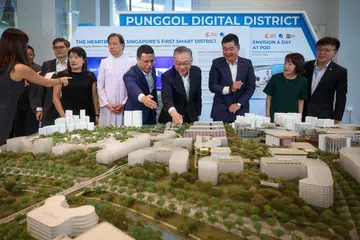 Menteri Pendidikan, Encik Desmond Lee (lima dari kanan), dan Timbalan Perdana Menteri, Encik Gan Kim Yong (empat dari kanan), antara ahli Jawatankuasa Pengurusan Maktab Rendah Catholic (CJC), yang meninjau model Daerah Digital Punggol (PDD) semasa acara media mengenai pemindahan kampus CJC ke PDD.