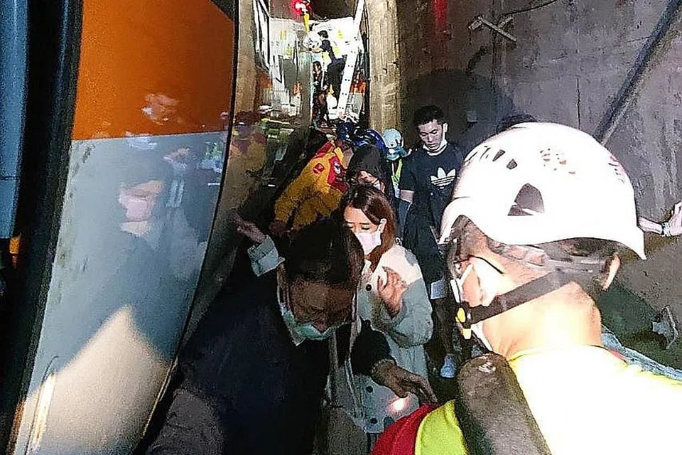 SEMPIT: Penumpang terpaksa berjalan di sepanjang landasan terowong kereta api yang sempit selepas nahas berlaku. - Foto AFP