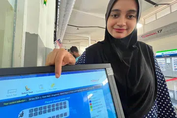 Kakitangan Terminal 17 di Shah Alam, Selangor, Cik Sarah Shkh Ibrahim, 23, menunjukkan tiket bas ekspres untuk perjalanan Shah Alam - Singapura bermula 28 hingga 30 Mac habis dijual.