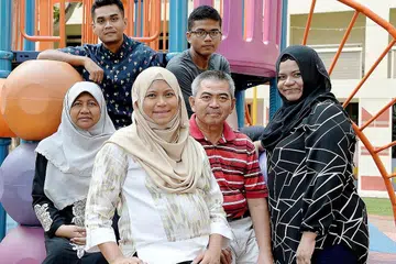 HUBUNGAN MESRA KUNCI KEJAYAAN: Cik Sarah (depan) bersama anggota keluarganya - (barisan tengah, dari kiri) ibunya, Cik Salimah; ayahnya, Encik Salim; dan kakak, Cik Siti Rafidah; serta (barisan belakang, dari kiri) suami, Encik Muhammad Ridha; dan adik, Encik Mohd Shahied. - Foto ZAINAL YAHYA