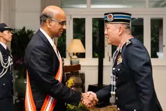 Presiden Singapura, Encik Tharman Shanmugaratnam (kiri), menyampaikan Darjah Utama Bakti Cemerlang kepada Pesuruhjaya Polis Diraja Brunei, Dato Paduka Seri Haji Mohammad Irwan Haji Hambali.