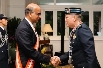 Presiden Singapura, Encik Tharman Shanmugaratnam (kiri), menyampaikan Darjah Utama Bakti Cemerlang kepada Pesuruhjaya Polis Diraja Brunei, Dato Paduka Seri Haji Mohammad Irwan Haji Hambali.