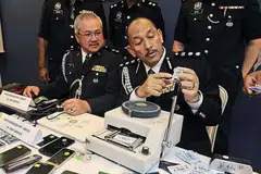 Timbalan Ketua Jabatan Siasatan Jenayah Komersial Pulau Pinang, Superintenden Teh Eng Hin (kiri), dan ACP Mior melihat kad kredit klon semasa sidang media di Ibu Pejabat Polis George Town. 