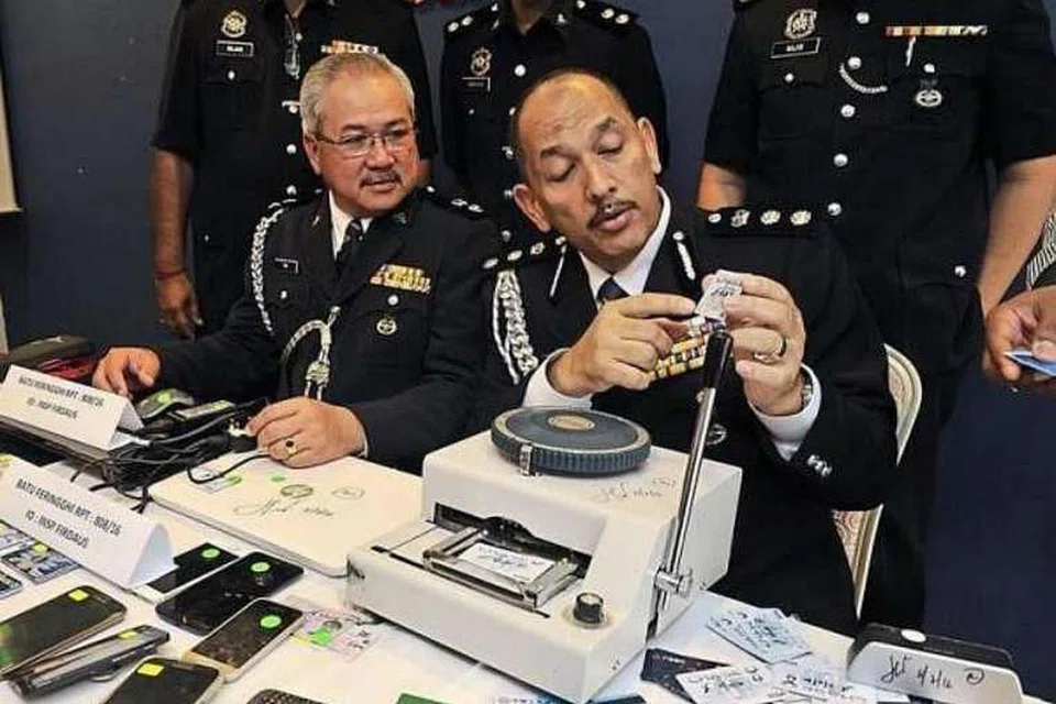 Timbalan Ketua Jabatan Siasatan Jenayah Komersial Pulau Pinang, Superintenden Teh Eng Hin (kiri), dan ACP Mior melihat kad kredit klon semasa sidang media di Ibu Pejabat Polis George Town. 