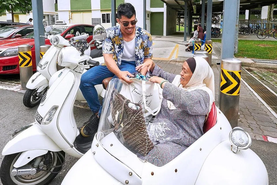 PENGALAMAN UNIK: Cik Sainah Sulaiman menaiki motosikal Vespa berkereta tepi yang dibawa sukarelawan Encik Nazarudin Rozali untuk ke acara 'We Care Day' anjuran Masjid Assyakirin di Boon Lay Sabtu lalu. Di acara itu, Cik Sainah menerima habuan Hari Raya termasuk baju kurung dan kuih-muih. - Foto BH oleh ROSLEE RAZAK 